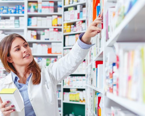 Photo,Of,A,Professional,Pharmacist,Checking,Stock,In,An,Aisle Photo,Of,A,Professional,Pharmacist,Checking,Stock,In,An,Aisle